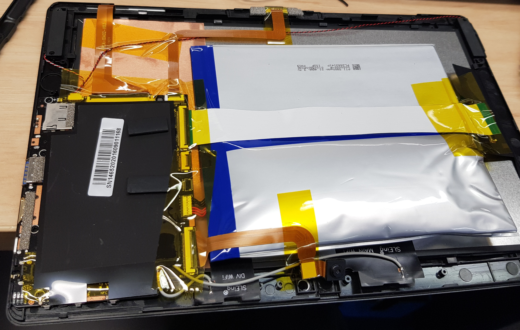 A partially dismantled tablet computer with a puffed up lithium polymer pouch cell.